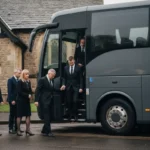 Family and friends boarding a funeral coach outside a UK church