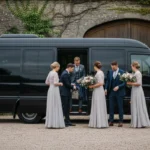 Small wedding party boarding an unbranded minibus at a UK countryside venue